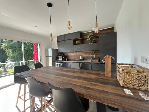 une cuisine avec une grande table et des chaises en bois dans l'établissement Villa du lac Naussac accès direct à la plage, à Langogne