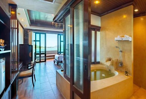 a large bathroom with a tub in a room at Racha Kiri Resort & Spa, Khanom in Khanom