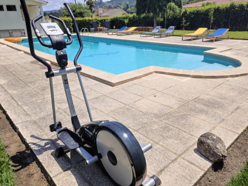 a machine is parked next to a swimming pool at CRALS - Casa do Corgo in Barroselas
