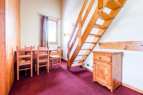une salle à manger avec une table et un escalier en bois dans l'établissement Quartier Crève Cœur - maeva Home - 2 Pièces 5 Personnes Confort MAE-3793, à Valmorel