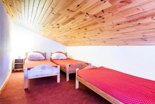 une chambre avec deux lits et un plafond en bois dans l'établissement Quartier Crève Cœur - maeva Home - 2 Pièces 5 Personnes Confort MAE-3793, à Valmorel