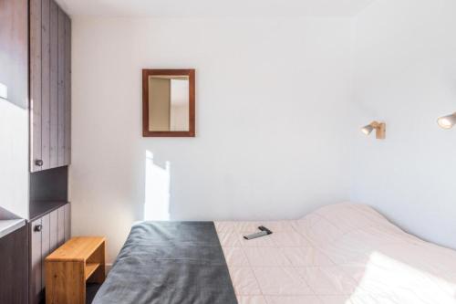 une chambre avec un lit et un miroir au mur dans l'établissement Résidence Les Fontaines Blanches - maeva Home - 2 Pièces 4 Personnes Sélection MAE-4095, à Morzine