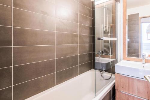 une salle de bain avec une baignoire et un lavabo dans l'établissement Résidence Les Fontaines Blanches - maeva Home - 2 Pièces 4 Personnes Sélection MAE-4095, à Morzine