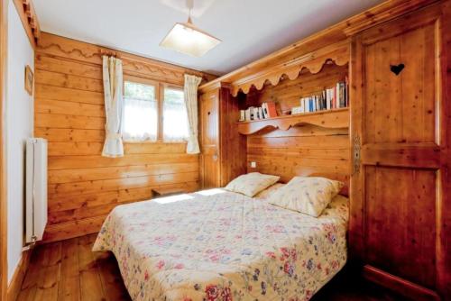 une chambre avec un lit dans une pièce en bois dans l'établissement Résidence Les Fermes de Méribel - maeva Home - 2 Pièces 4 Personnes Sélection MAE-4097, à Les Allues