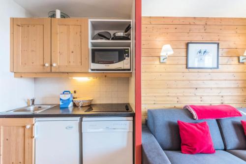 Il comprend une petite cuisine avec un canapé et un four micro-ondes. dans l'établissement Résidence Quartier Falaise - maeva Home - 2 Pièces 4 Personnes Prestige MAE-4127, à Avoriaz