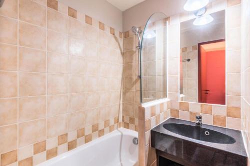une salle de bain avec un lavabo et une baignoire dans l'établissement Résidence Quartier Falaise - maeva Home - 2 Pièces 4 Personnes Prestige MAE-4127, à Avoriaz