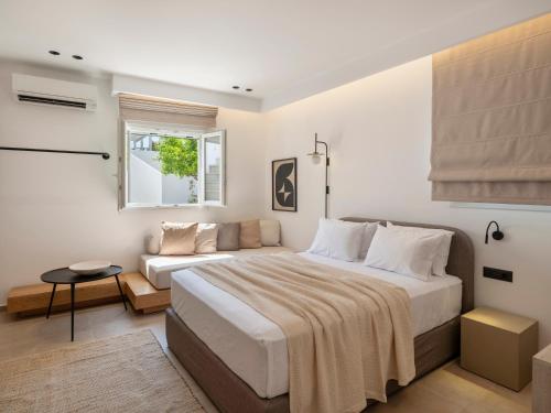 a bedroom with a large bed and a couch at Anemelia way of living in Naousa