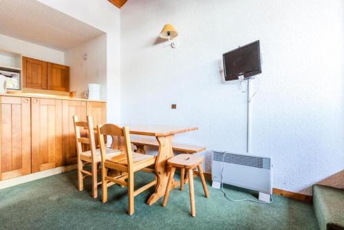 Il comprend une cuisine avec une table et des chaises ainsi qu'une télévision. dans l'établissement Quartier Crève Cœur - maeva Home - Studio 4 Personnes Confort MAE-4102, à Valmorel
