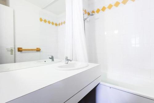 une salle de bain blanche avec deux lavabos et un miroir dans l'établissement Quartier Crève Cœur - maeva Home - Studio 4 Personnes Confort MAE-4102, à Valmorel