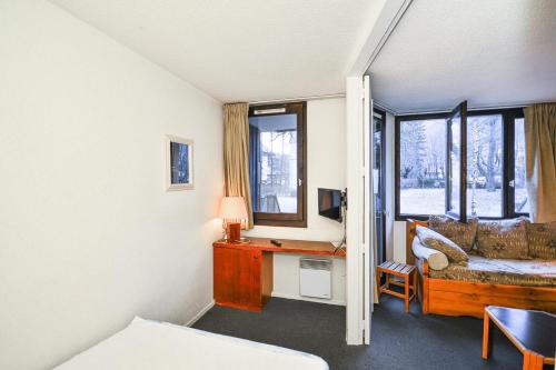 une chambre avec un bureau et un canapé dans l'établissement L'Aiguille - maeva Home - 2 Pièces 5 Personnes - Sélection MAE-4175, à Chamonix-Mont-Blanc