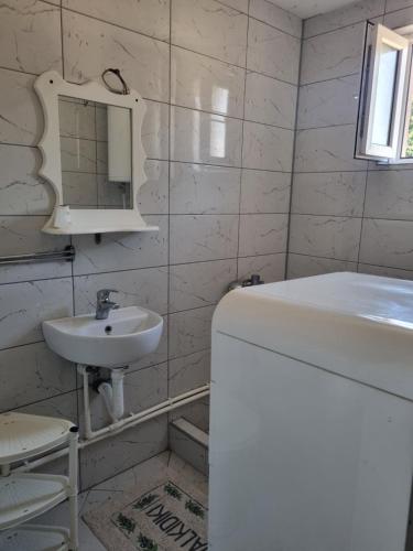 a white bathroom with a sink and a mirror at Ana LUX in Dobrosin