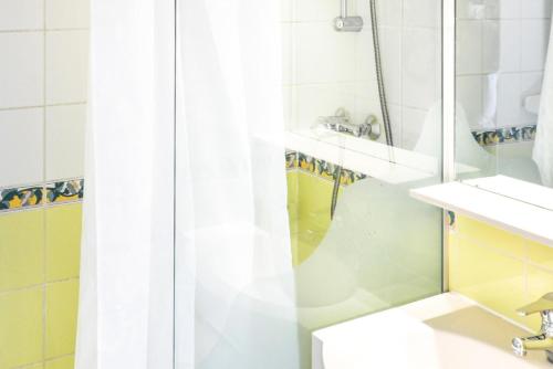 une salle de bain avec un rideau de douche et un lavabo dans l'établissement Résidence Les Horizons d'Huez - maeva Home - Studio 4 personnes - Sélection MAE-4178, à Huez