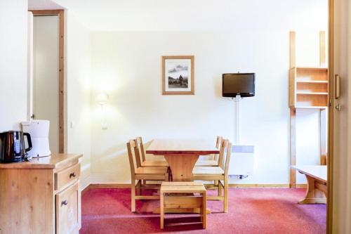 Il comprend une cuisine avec une table et des chaises ainsi qu'une télévision. dans l'établissement Quartier La Forêt - maeva Home - Studio 4 Personnes Confort MAE-4163, à Valmorel