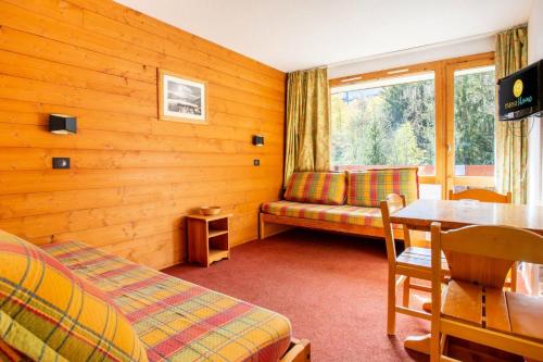 une chambre avec un canapé, une table et une fenêtre dans l'établissement Quartier La Forêt - maeva Home - Studio 3 Personnes Confort MAE-4169, à Valmorel