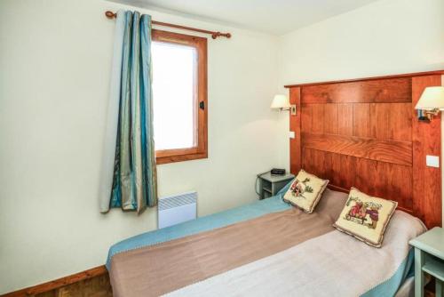 une chambre avec un lit avec deux oreillers dessus dans l'établissement Résidence La Marelle et Le Rami - maeva Home - 2 Pièces 6 Personnes Sélection MAE-4180, à La Plagne Tarentaise