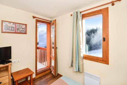 un salon avec une télévision et une fenêtre dans l'établissement Résidence La Marelle et Le Rami - maeva Home - 2 Pièces 6 Personnes Sélection MAE-4180, à La Plagne Tarentaise