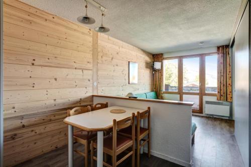 d'une salle à manger avec une table et des murs en bois. dans l'établissement Résidence Le Hameau du Sauget - maeva Home - 2 Pièces 4 Personnes Confort MAE-4185, à La Plagne Tarentaise