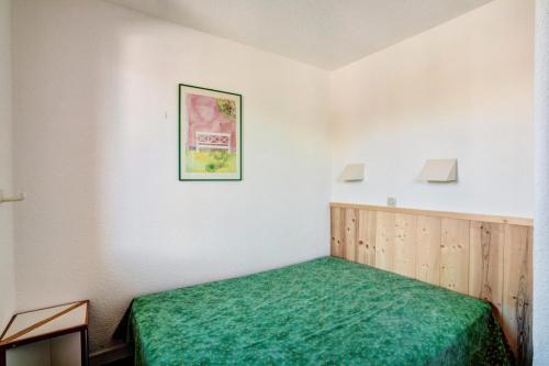 - une chambre avec un lit vert dans l'établissement Résidence Le Hameau du Sauget - maeva Home - 2 Pièces 4 Personnes Confort MAE-4185, à La Plagne Tarentaise