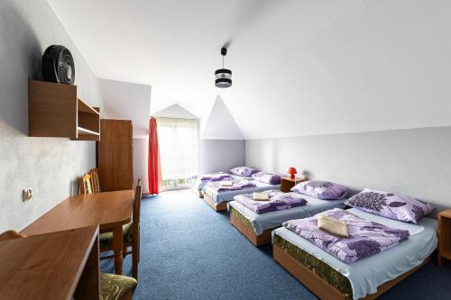 a room with four beds with purple pillows at Pensjonat Złoto Bałtyku in Łeba