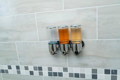 a group of four glass cups hanging on a wall at Gae La Rona Self Catering Apartment in Gaborone