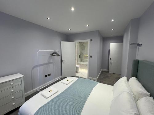 a bedroom with a large bed and a bathroom at Queen Apartment - High Spec - En-Suites - 7 Guests in Abingdon