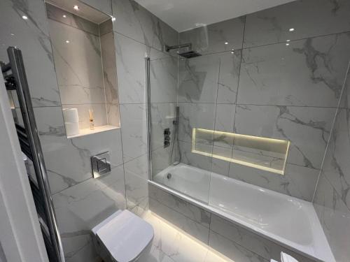 a bathroom with a shower and a tub and a toilet at Queen Apartment - High Spec - En-Suites - 7 Guests in Abingdon