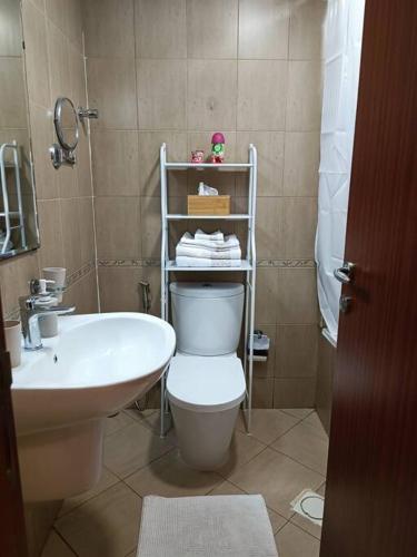a bathroom with a white toilet and a sink at Modern Studio Oasis - Skyline Views, Private Balcony & Workspace in Ajman