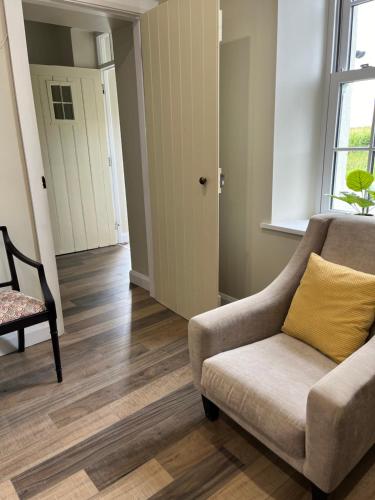 a living room with a couch and a chair at Old Post Office in Linsfort