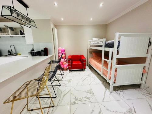 a room with two bunk beds and a kitchen at Spacious One Bed Property in Wembley in London
