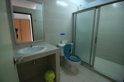 a bathroom with a toilet and a sink and a shower at Beachfront Hotel Cha Am in Cha Am