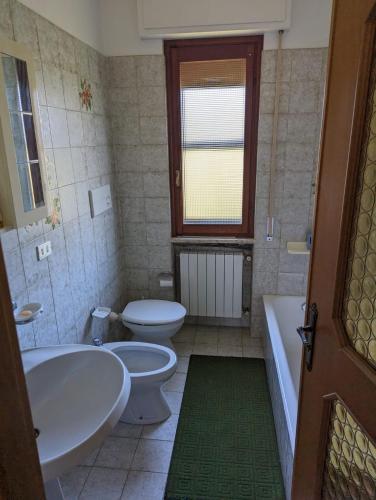 a bathroom with two toilets and a tub and a sink at La Casa di Bet in San Lorenzo al Mare
