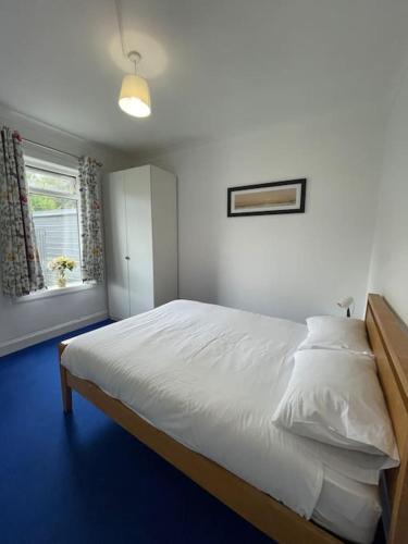 a bedroom with a bed with white sheets and a window at 2 Bedrooms Holiday home in Edinburgh near City Center in Edinburgh
