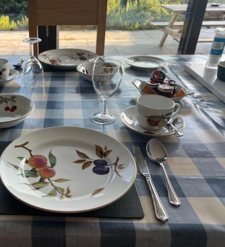 a table with plates and cups and spoons on it at Seafront BnB at Botany in Kent