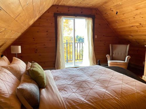 a bedroom with a large bed in a room with a window at Terrasses Kedros Exitchalets Spa & Lake Acces in Entrelacs