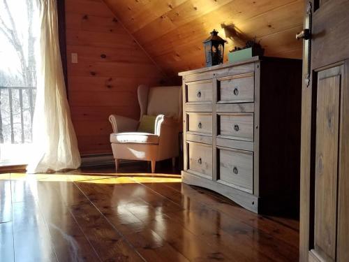 a bedroom with a dresser and a chair and a window at Terrasses Kedros Exitchalets Spa & Lake Acces in Entrelacs