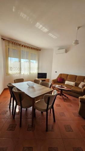 a living room with a table and chairs and a couch at Fani's Apartment in Durrës