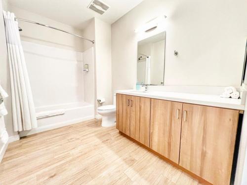 Un baño con lavabo, inodoro y espejo. en The Executive Getaway, en San Diego