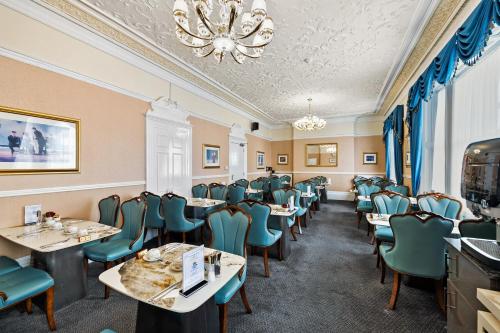 a dining room with tables and chairs and a chandelier at Drake Hotel Plymouth in Plymouth