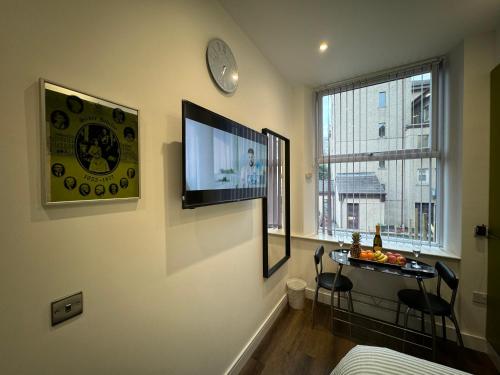 a living room with a television and a table with chairs at Luxury 6-Bed House - 6 En Suite- Jaquzzi Baths - Private Parking - Sleeps 22- 2 Min M62 in Elland