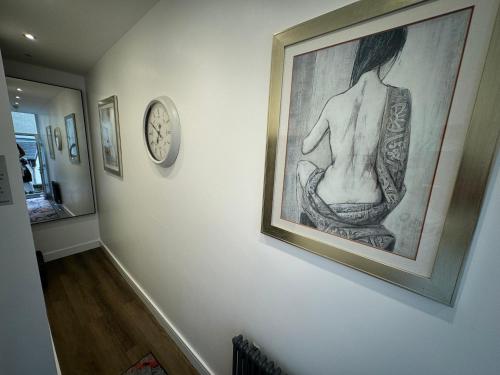 a picture of a woman on a wall with a clock at Luxury 6-Bed House - 6 En Suite- Jaquzzi Baths - Private Parking - Sleeps 22- 2 Min M62 in Elland