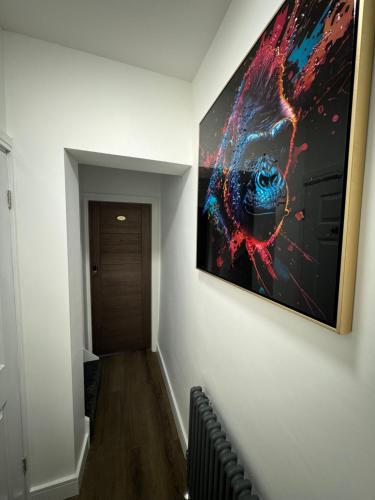 a hallway with a painting hanging on a wall at Luxury 6-Bed House - 6 En Suite- Jaquzzi Baths - Private Parking - Sleeps 22- 2 Min M62 in Elland