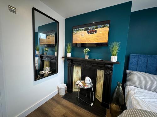 a bedroom with a fireplace and a tv on the wall at Luxury 6-Bed House - 6 En Suite- Jaquzzi Baths - Private Parking - Sleeps 22- 2 Min M62 in Elland