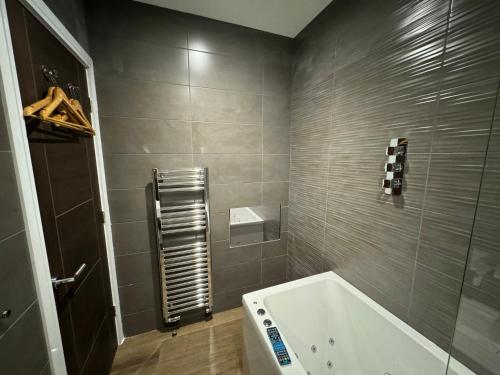 a bathroom with a white tub and a shower at Luxury 6-Bed House - 6 En Suite- Jaquzzi Baths - Private Parking - Sleeps 22- 2 Min M62 in Elland