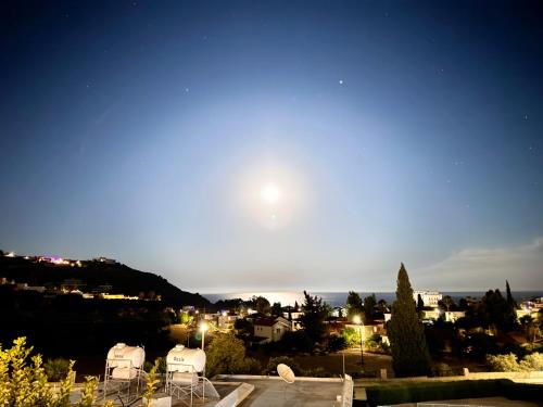 a view of the moon over a city at night at Pissouri Image in Pissouri