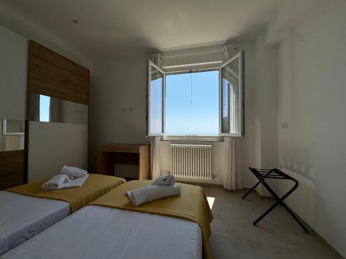 two beds in a room with a large window at Ca' dii Bürsa - HOMY 5 TERRE in Volastra