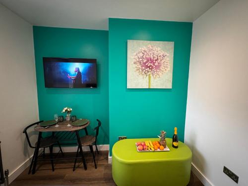 a room with a table and a green ottoman and a table at Luxury 6-Bed House - 6 En Suite- Jaquzzi Baths - Private Parking - Sleeps 22- 2 Min M62 in Elland