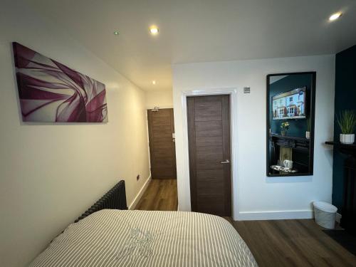 a bedroom with a bed and a door to a hallway at Luxury 6-Bed House - 6 En Suite- Jaquzzi Baths - Private Parking - Sleeps 22- 2 Min M62 in Elland