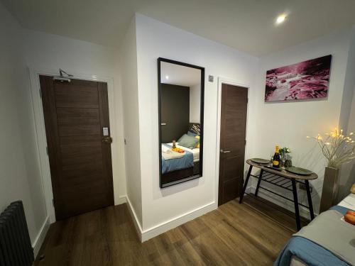 a room with a mirror and a bed and a table at Luxury 6-Bed House - 6 En Suite- Jaquzzi Baths - Private Parking - Sleeps 22- 2 Min M62 in Elland