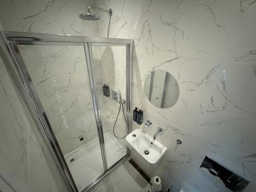 a white bathroom with a shower and a sink at Luxury 6-Bed House - 6 En Suite- Jaquzzi Baths - Private Parking - Sleeps 22- 2 Min M62 in Elland