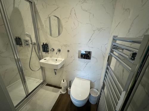 a bathroom with a toilet and a sink and a shower at Luxury 6-Bed House - 6 En Suite- Jaquzzi Baths - Private Parking - Sleeps 22- 2 Min M62 in Elland